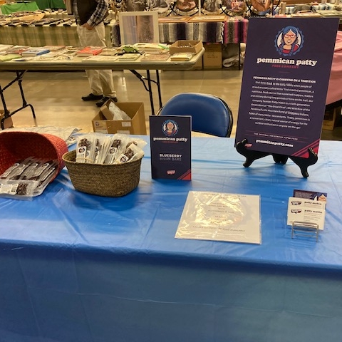 Set up at one of the first in-person events, a table displays products and brand marketing material